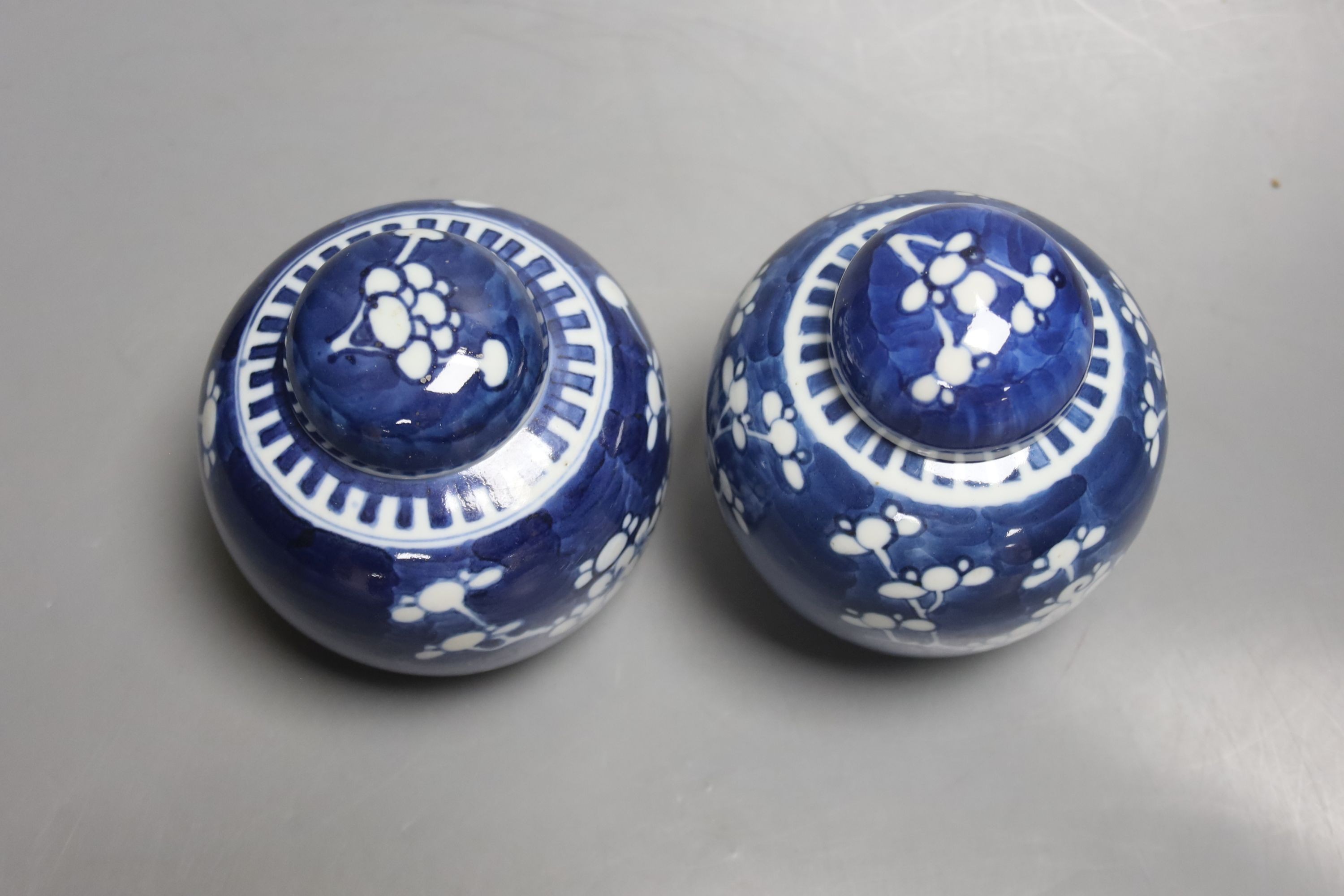 A pair of early 20th century blue and white prunus jars and covers